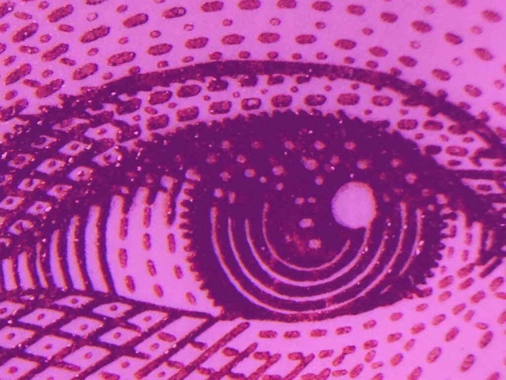 Artistic close up image of eye on pink background